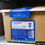중식 냉동제품 유통기한 - A detailed close-up of a frozen Chinese food package inside a modern household freezer, showing clea...